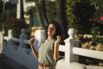 Canvas Print - Closeup shot of a Spanish female posing in front of the white gate