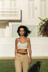 Canvas Print - Vertical shot of a Spanish female posing in front of the white building