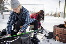 Teenage Friends Preparing For Ice Hockey At Winter Park