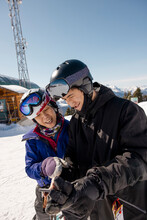 Mother And Son Skiers Using Smart Phone At Sunny Ski Resort