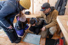 Family Ice Fishing In Heated Shelter