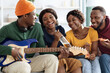 Carefree beautiful black friends playing guitar, singing