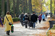 Ludzie odwiedzający cmentarz jesienią w święto zmarłych. 