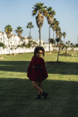 Canvas Print - Vertical shot of a Spanish caucasian curly female posing in the park