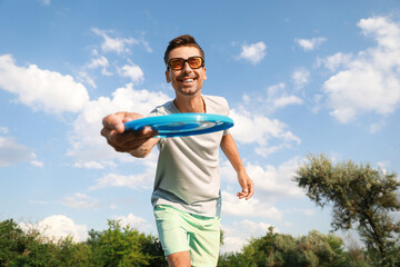 Wall Mural - Young man playing frisbee in park