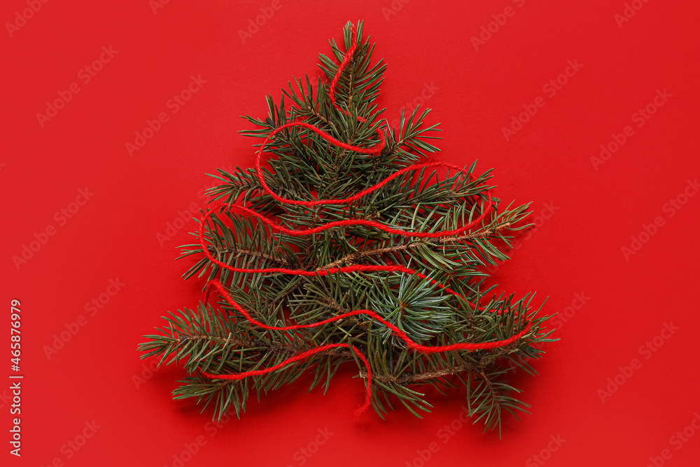 Christmas tree made of fir branches on red background