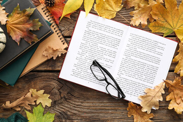 Wall Mural - Composition with open book, eyeglasses and autumn leaves on wooden background