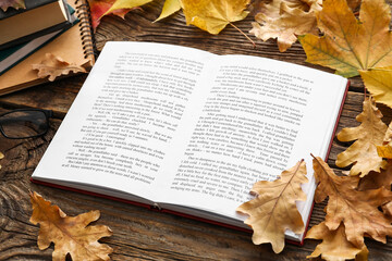 Wall Mural - Open book and autumn leaves on wooden background