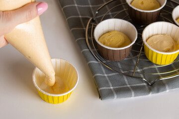 Making cupcakes. Сapsules for cupcakes, cupcake molds. dough distribution