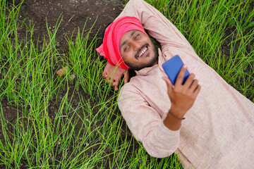 Poster - Indian farmer using on smartphone at agriculture field.