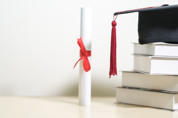 Close-up of a mortarboard and degree certificate on the table. Education Concept Stock Photo