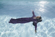 © Milou Dirks - Abstract portrait of a girl floating in purple dress in pool like an angel in summer