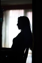 The Silhouette Of A Woman Sitting On A Chair
