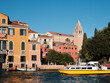 Grand Canal in Venice, Italy. Passenger vaporetto boat and historic buildings with church bell tower, belfry. Venetian passenger water transport, logos removed for commercial use.