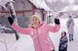 © Елена Алябьева - An elderly woman laughs happily while walking on the street in winter with her grandchildren