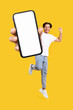 Man showing white empty smartphone screen and jumping up high