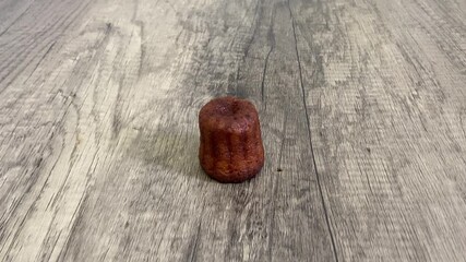 Poster - Canelé bordelais sur une table en bois