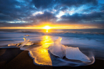 Wall Mural - Diamond beach in Vatnajokull, southern Iceland. Sunrise shot of chunks of ice on the black sand rom the Jokulsarlon glacier lagoon