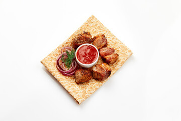 Wall Mural - shashlik on thin pita bread with sauce and red onion rings on white background