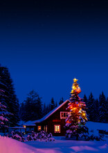 The Snowy Cabin In The Woods With A Christmas Decorated Tree And Dark Sky At Evening