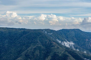 mountain valley with dramatic sunset sky and low clouds at evening