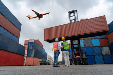 Wall Mural - Industrial worker works with co-worker at overseas shipping container port . Logistics supply chain management and international goods export concept .