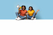 © Prostock-studio - Emotional black couple sitting on empty horizontal board for advertisement