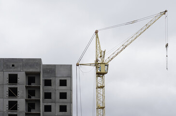 There is a crane near a multi-storey building under construction.