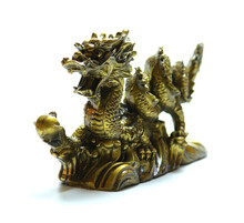 Figurine Of A Dragon Holding A Pearl In Its Paw On White Background