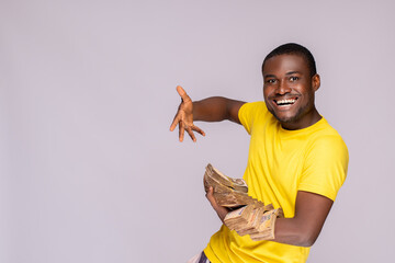 Wall Mural - young nigerian man holding a lot of cash feeling excited and happy