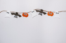 Homemade Garland On A Jute Rope Made Of Pumpkin, Bat And Ghosts With Eyes On A White Background With A Place For Text