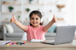 © Prostock-studio - Little Arab Schoolgirl Showing Thumbs Up While Study With Laptop At Home