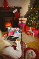 Poster - Santa claus making christmas laptop video call with happy, smiling senior african american couple