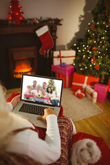 Poster - Santa claus making christmas laptop video call with happy caucasian multi generation family