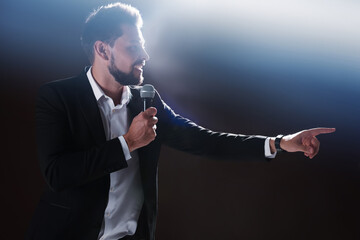 Wall Mural - Motivational speaker with microphone performing on stage