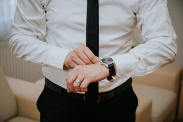 Canvas Print - Shot of the groom putting on watched at a wedding in Sarajevo, Bosnia and Herzegovina