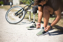 Close-up Of Person With Disability Tying Laces. Man With Mechanical Leg Getting Ready For Riding Bicycle. Sport, Disability Concept