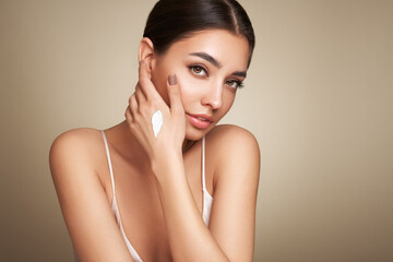 Wall Mural - Beauty woman applying cream on her hands. Young woman with clean fresh skin