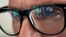 Focused Crypto Trader Analyst Wearing Eyeglasses Working Looking At Computer Screen Reflecting In Glasses Analyzing Online Trading Stock Exchange Market Data Charts. Close Up Eye Reflection.