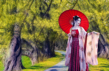 Wall Mural - Asian women dressed in Chinese costumes standing in the yellow flower tunnel.