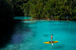 Summer holidays vacation travel. SUP Stand up paddle board. Young woman sailing on beautiful calm lagoon.