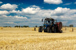 © vladimircaribb - Tractor with bale machine for harvesting straw in the field and making large round bales. Agricultural work, harvesting hay on the hills in summer field
