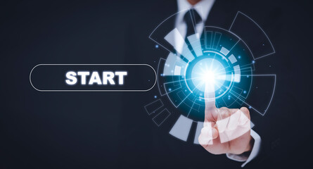 Poster - Businessman press start future button with virtual light, Start button with spot light on blue background, pressing power button over computer. Start or shut down concept.