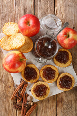 Wall Mural - Homemade Sweet Apple Butter with Cinnamon and Nutmeg closeup in the jar and toasts on the table. Vertical top view from above