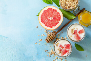 Sticker - Vegan healthy breakfast. Granola with greek yogurt, honey and grapefruit in a glass. Top view flat lay background. Copy space.