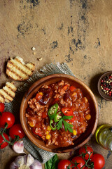 Wall Mural - Traditional mexican dish chili con carne - spicy minced meat with vegetables in tomato sauce. Top view with copy space.