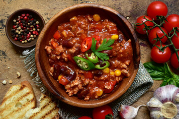 Wall Mural - Traditional mexican dish chili con carne - spicy minced meat with vegetables in tomato sauce. Top view with copy space.