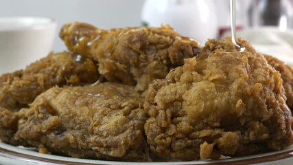 Poster - Pouring honey onto fried chicken close up slow motion