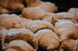 fresh croissants in different flavors with sugor on top. delicious sweet pastries for breakfast.