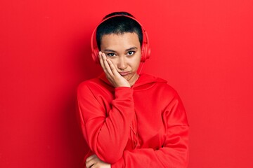 Poster - Beautiful hispanic woman with short hair listening to music using headphones thinking looking tired and bored with depression problems with crossed arms.